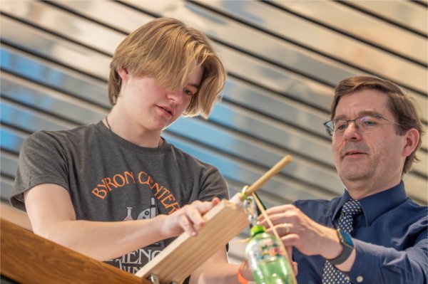 Two people concentrate on a project from an elevated area.