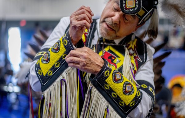 Greg Morsaw puts on his regalia for the men's northern traditional dance during the 23rd "Celebrating All Walks of Life" Pow Wow April 13.