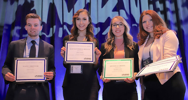 four students holding award certificates
