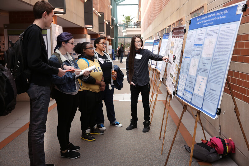 group of people looking at a poster
