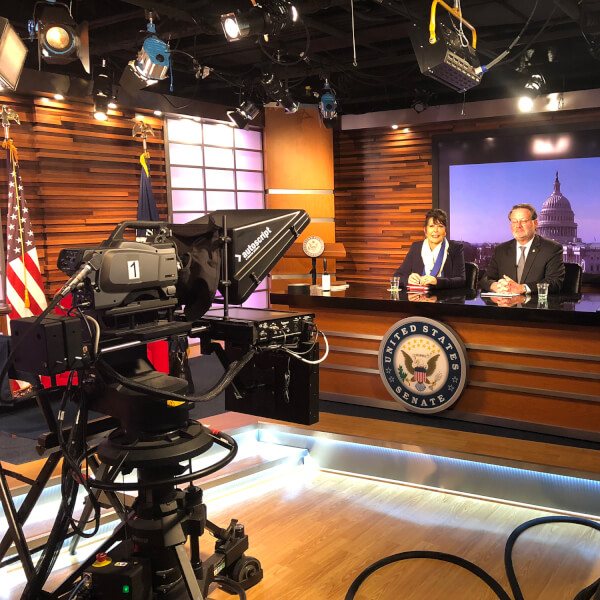 President-elect Philomena Mantella, left, sits with U.S. Sen. Gary Peters during a media availability in Washington D.C.  The two are seated at a desk in a television studio in the U.S. Senate offices. 