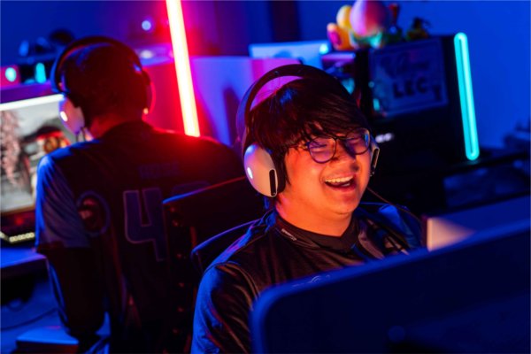  Colorful bands of light highlight a laughing college student as they participate in esports. 