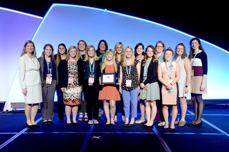 group standing on stage with award