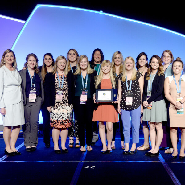 group standing on stage with award