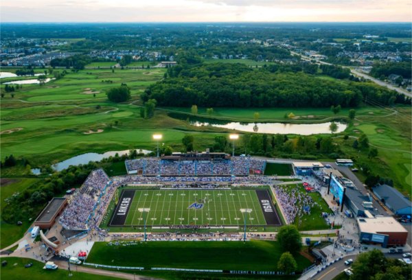  A drone photo of a college football stadium with a golf course in the background. 