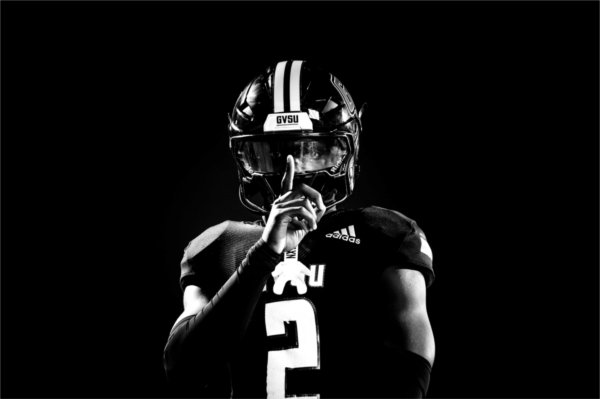 A college football players gestures a hush sign with his hand. 