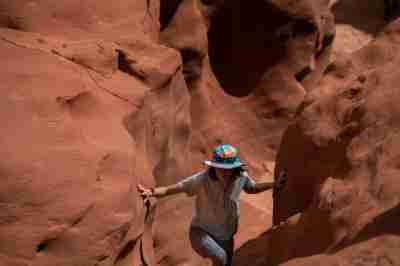 A person walks through an opening in canyon walls.