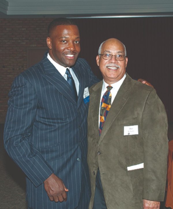 Ray Bennett, left, and Don Williams Sr. standing with arms around each other, wearing suits