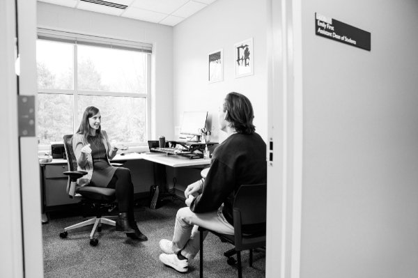 Assistant Dean of Students talks with a student in her office. 