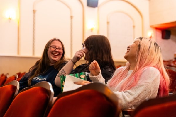 Stephanie Phyu (right), Emma Ciavone (center) and Loren Karschnia (left), amongst eachother before the start of the Summer Film Project&#8217;s 30th anniversary screening at Wealthy Theatre on April 30, 2026. All three students are involved in an upcoming Summer Film Project production.