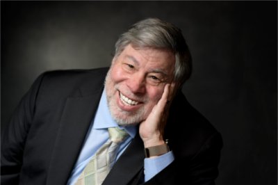 Portrait of Steve Wozniak in jacket and tie leaning against his left hand. 