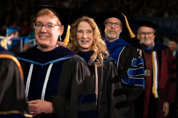four people in academic regalia during a commencement