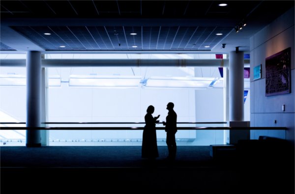 A silhouette of a couple at a fancy dinner chat together. 