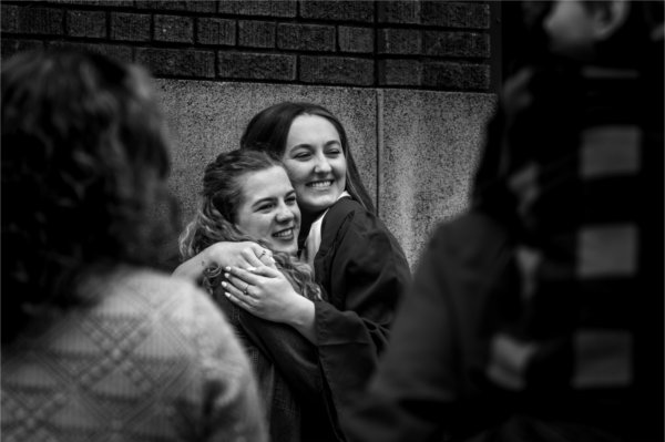 Two people hug after a Commencement ceremony.