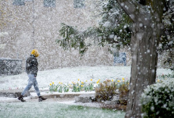 A person walks through snowy campus.