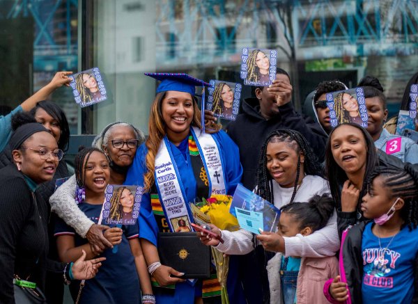 Family surrounds a college graduate to pose for a photo.