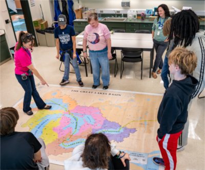 Science instructor Brittany Sweezer, far left, talks about the Great Lakes to Crossroads Charter Academy students from Big Rapids as part of an educational visit to the Annis Water Resources Institute.