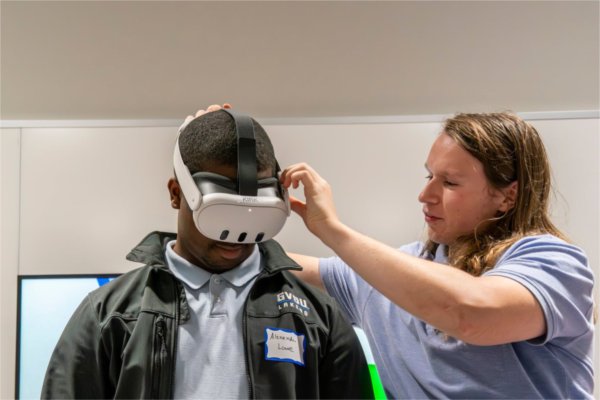 Simulation Emerging Technologies Developer Owen Mearns, right, helps Data Scientist Alexander Lowe get ready for a virtual reality interactive simulation during the GV Technology Summit at DeVos Center for Interprofessional Health on October 2. (Photo release on file)