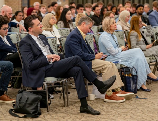 Audience members listen to a presentation