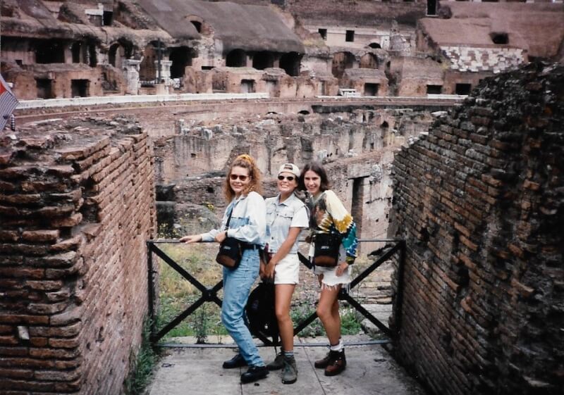 three people standing before ruins