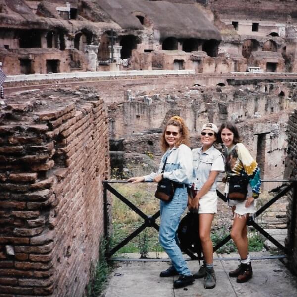 three people standing before ruins
