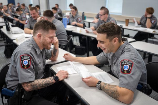 Benjamin Medina (left) and Ethan Ettinger (right) critique each others police reports in Police Academy classroom, Dec. 2, 2025.