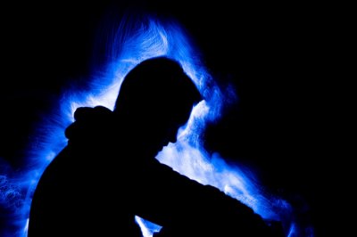 A silhouette of a person with blue light around them.