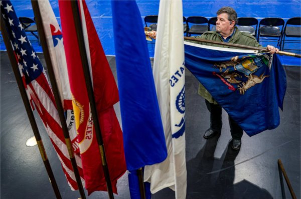 Brant Mitchell, of the Gun Lake Ogitch-E-Daa Society, prepares the colors for the All Walks of Life Traditional Powwow at the Fieldhouse on April 4