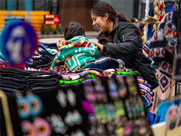 Nusta Campo shares a moment with son Saul while setting up the Kichwa Traders booth during the All Walks of Life Traditional Powwow at the Fieldhouse on April 4.