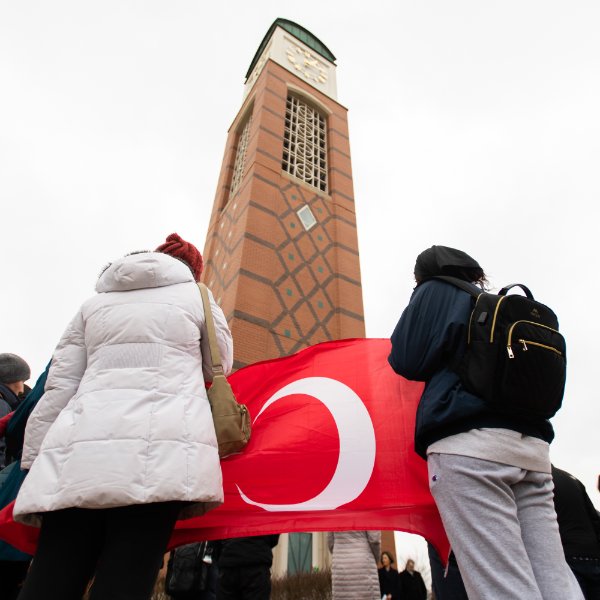 Students hold the Turkish flag in front of the Cook Carillon Tower during a vigil.