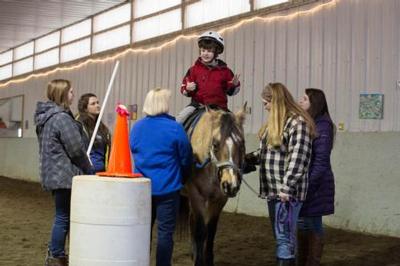 Davide Cirilli rides Twiz while he works with Beth Macauley during a therapy session at CHUM.