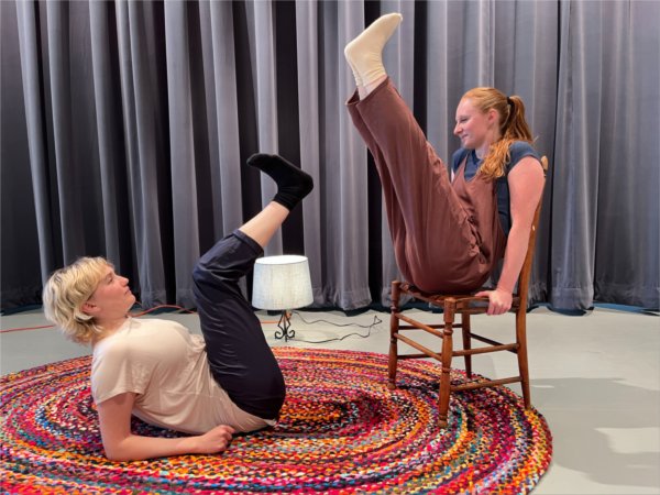 Kaye Suarez and O&#8217;Malley Ferguson perform a dance on stage, Kaye on left on floor with legs up, O'Malley on chair with legs up
