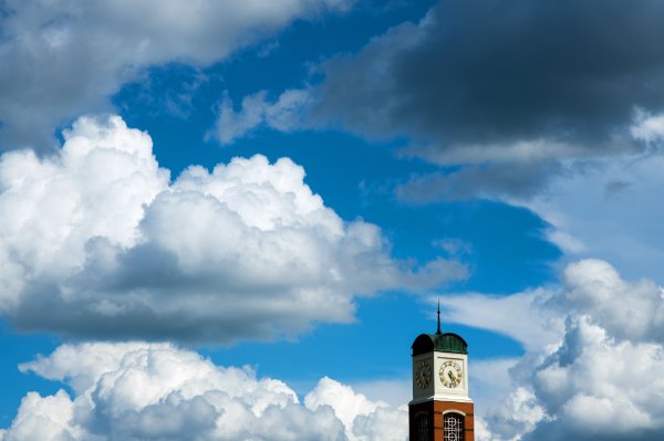 A carillon tower is seen against a blue sky full of puffy white clouds. 