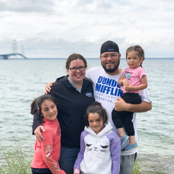 photo of family, with three small daughters, near the lakeshore with Mackinac Bridge in background
