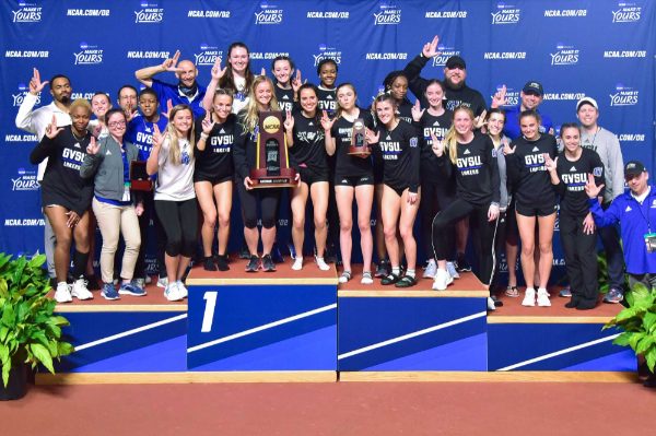 Coaches and the women's track and field team hold Laker Ls up on the national stage.