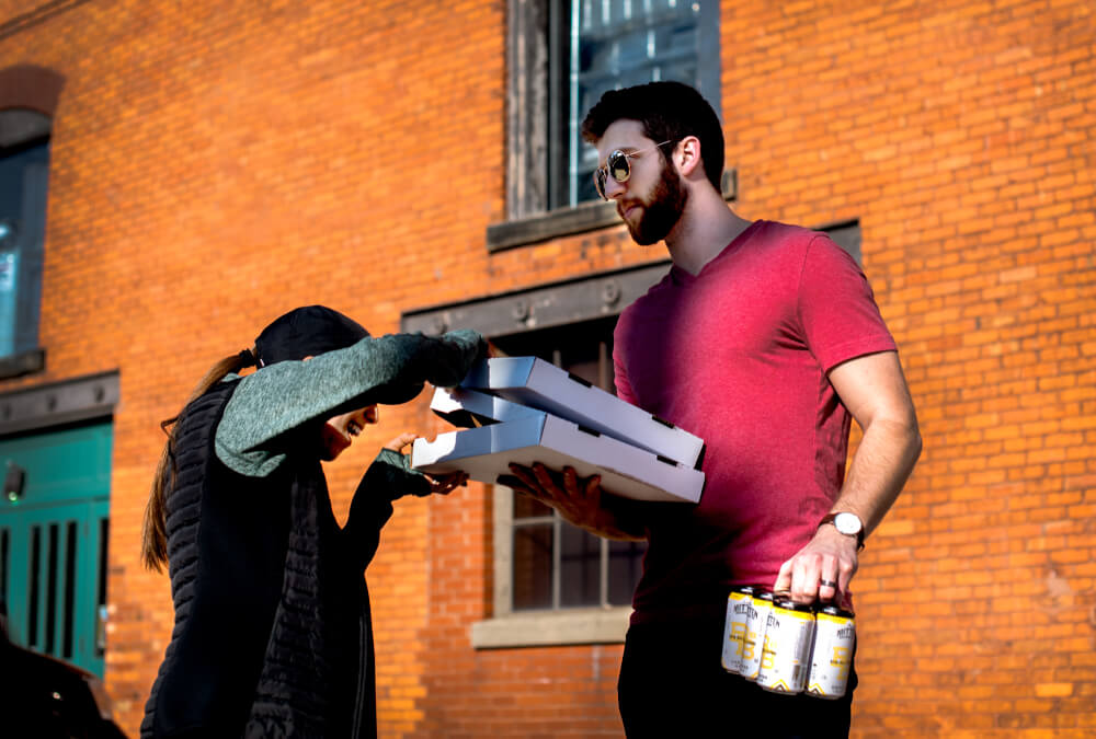 Grand Valley alum Nate Gillespie and his wife, Nichole, pick up pizza and beer from Mitten Brewing Company on April 2. The business was a "targeted spend" for the Coronavirus Civilian Corps, a group he is leading.