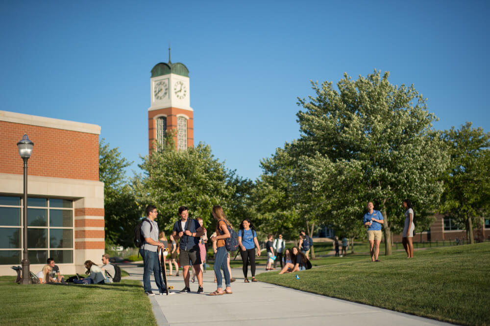 Students on Allendale Campus, carillon tower in background