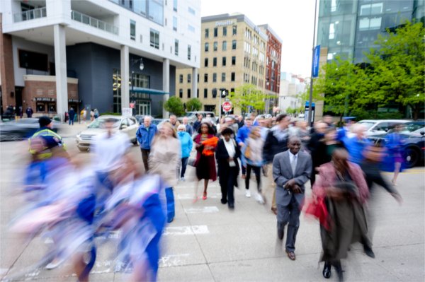Students and their families cross the street outside of Van Andel Arena before commencement May 1.