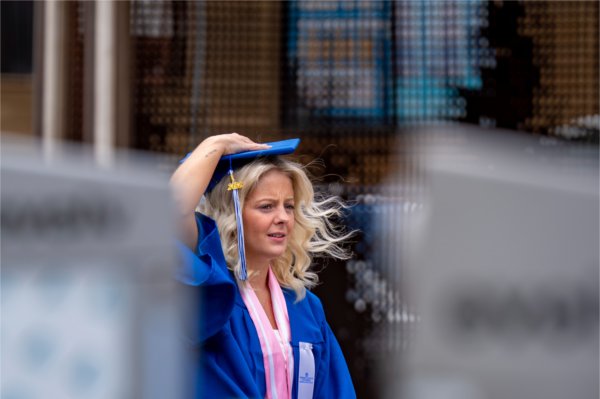 Soon-to-be graduate Nia Yost waits outside Van Andel Arena in the wind before the afternoon Commencement ceremony on May 2.