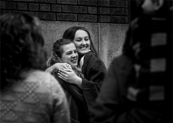 From left, Jacyln Brubaker hugs Avery Howe, who graduated with a bachelor of science in allied health sciences during Commencement at Van Andel Arena May 2.