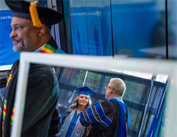 Student speaker Dallas Matthews talks with Mark Schaub, Brooks College of Interdisciplinary Studies Dean, inside the robing room before Commencement at Van Andel Arena on May 1. Also pictured is B. Donta Truss, vice president for Enrollment Development and College Futures. 
