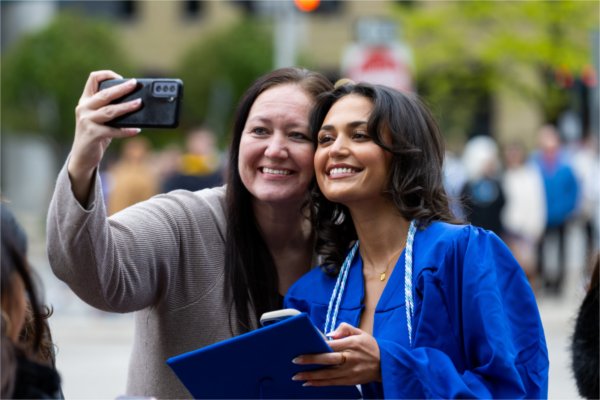 Joslyn Williams, who earned a bachelor&#8217;s degree in elementary education, takes a selfie with her mother outside Van Andel Arena before Grand Valley State University&#8217;s spring commencement on May 1, 2026.