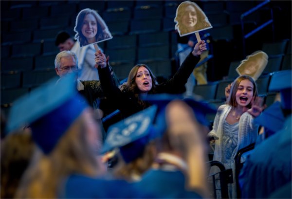 Family members try to get the attention of a graduate as they recess from Saturday afternoon&#8217;s Commencement ceremony at Van Andel Arena May 2. 