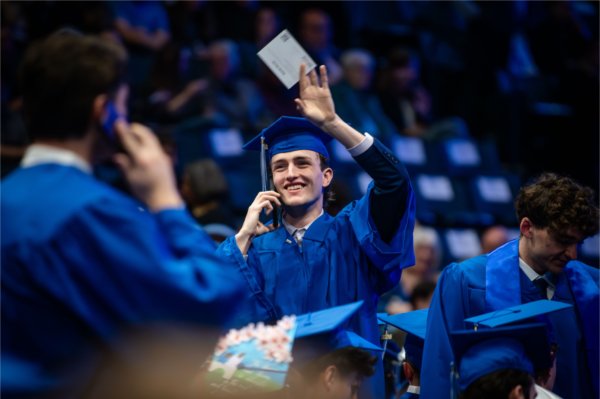 Jacob North, a finance major, waves to his loved ones in the crowd during Commencement at Van Andel Arena May 2.