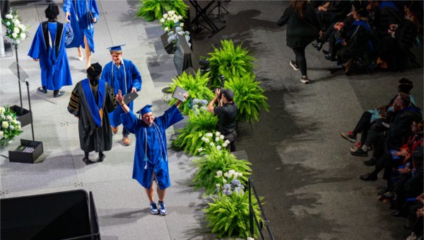 Graduates react while walk past the stage after receiving their diplomas during the Commencement ceremony at Van Andel Arena on May 1.