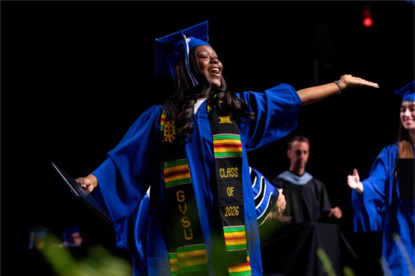 A graduate celebrates across the stage after receiving their diploma during the Commencement ceremony at Van Andel Arena Friday, May 1.