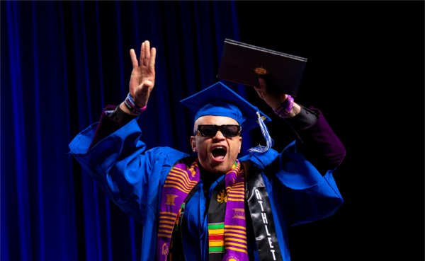 Sociology graduate Bwana Miller dances on the stage after receiving their diploma during the afternoon Commencement ceremony at Van Andel Arena on May 2.