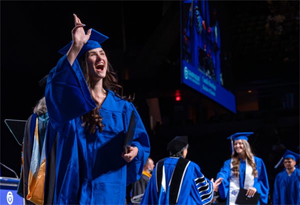 A graduate walks past the stage after receiving their diploma during the afternoon Commencement ceremony at Van Andel Arena on May 2.