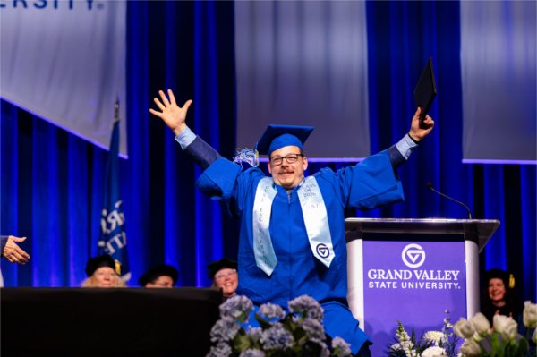 A graduate celebrates after receiving their diploma during the Commencement ceremony at Van Andel Arena Friday, May 1.