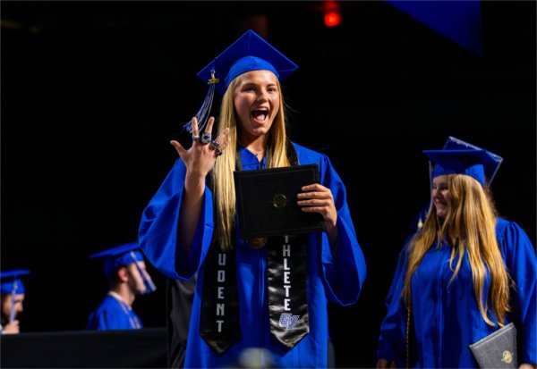 Paige VanStee raises her rings while crossing the stage during Commencement at Van Andel Arena on May 1.